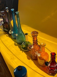 a row of colorful vases on a yellow background